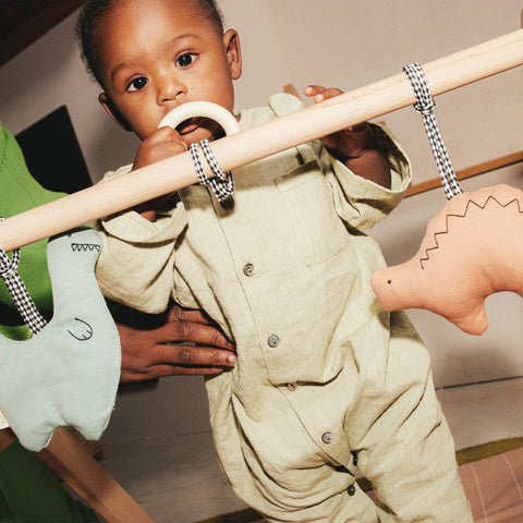 Infant playing with couture baby toy.