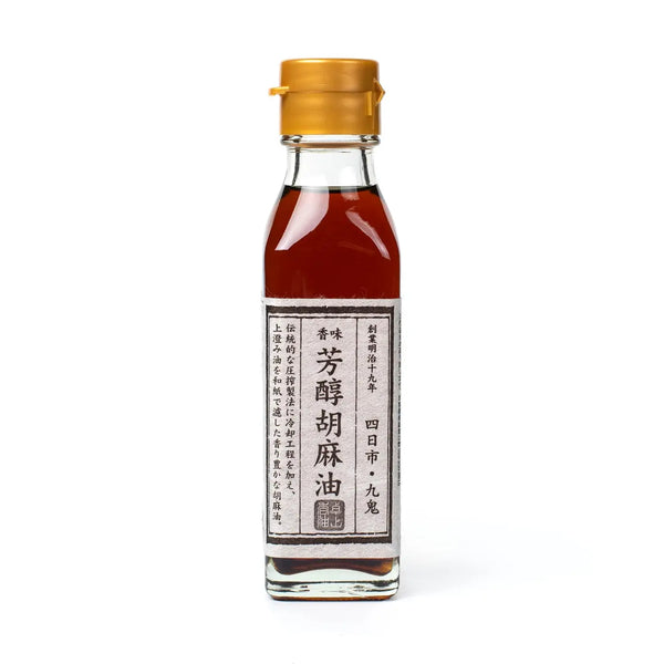 Bottle of sesame oil with a gold cap on a white background