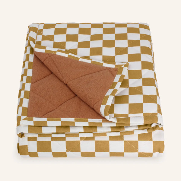 Folded checkered pet blanket with brown and white pattern on a white background
