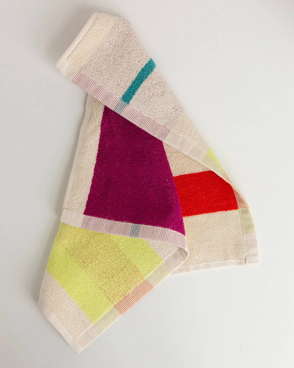 Colorful towel with geometric patterns on a light gray background