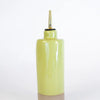 Yellow ceramic condiment bottle with a gold nozzle on a white background