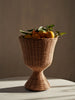 Wicker vase with lemons on a neutral background
