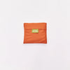 An orange compact pouch with a small green label reading 'ORIGINAL DUCKHEAD' in the center, set against a plain white background.
