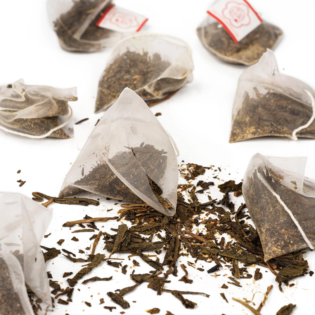Tea bags with loose tea leaves on a white background