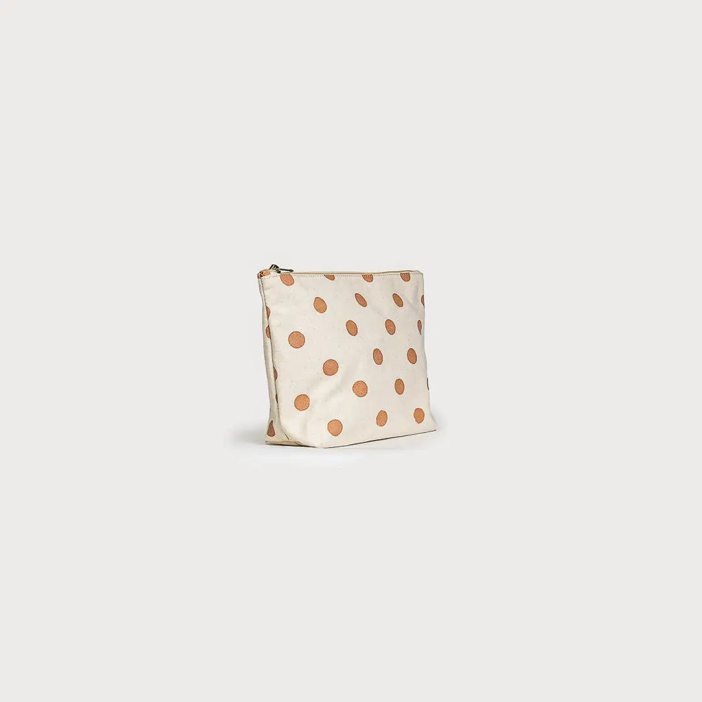Small pouch with orange polka dots on a beige background