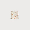 Small pouch with orange polka dots on a beige background