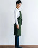 Person wearing a green apron against a white background