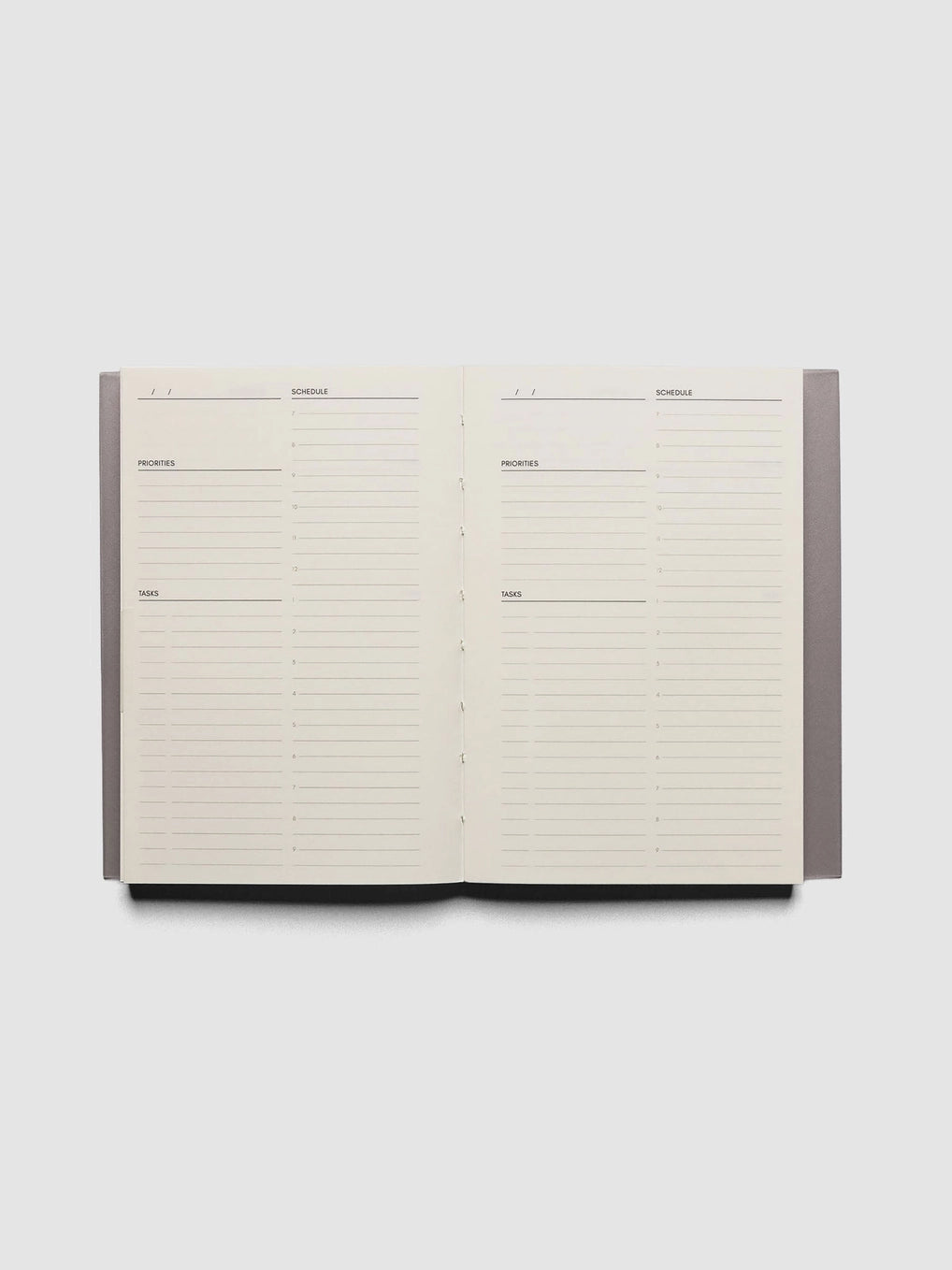 An open weekly planner notebook with lined pages for Monday through Sunday, photographed from above on a light gray background.