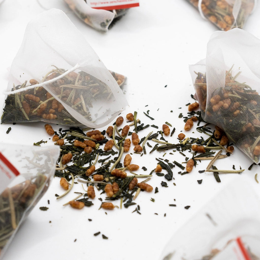 Tea bags with loose tea leaves on a white surface