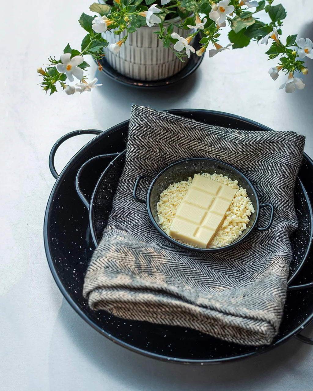 Butter in a bowl on a towel with flowers in the background