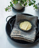 Butter in a bowl on a towel with flowers in the background