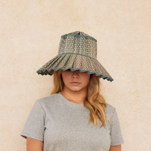 Person wearing a Lorna Murray Burano Capri Sun Hat against a beige background