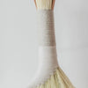Tampico broom with a woven handle on a light gray background