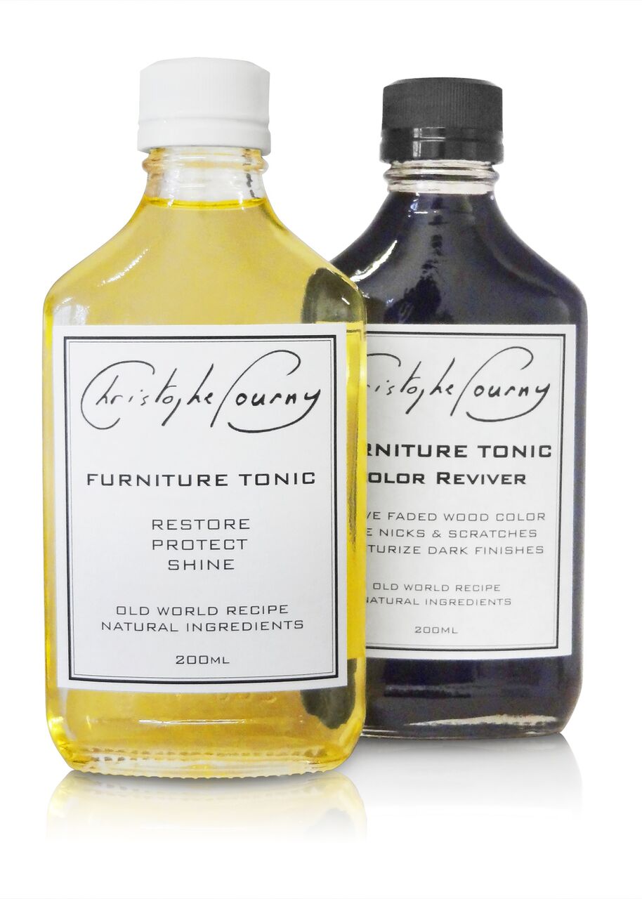 Two bottles of Christophe Gourney furniture care products on a white background