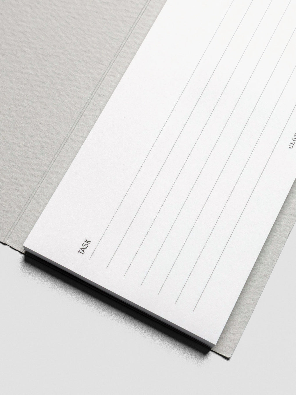 Close-up of a notebook with lined pages on a light gray background