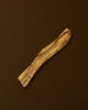Wooden spatula with olive wood pattern on a brown background