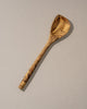 Wooden spoon with a textured handle on a beige background
