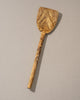 Wooden spatula with a textured handle on a beige background