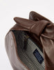 Brown leather bag with a bow detail on a white background