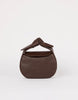 Brown leather handbag with a knot detail on a white background