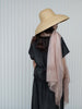 Person wearing a wide-brimmed hat and a light pink scarf against a white background