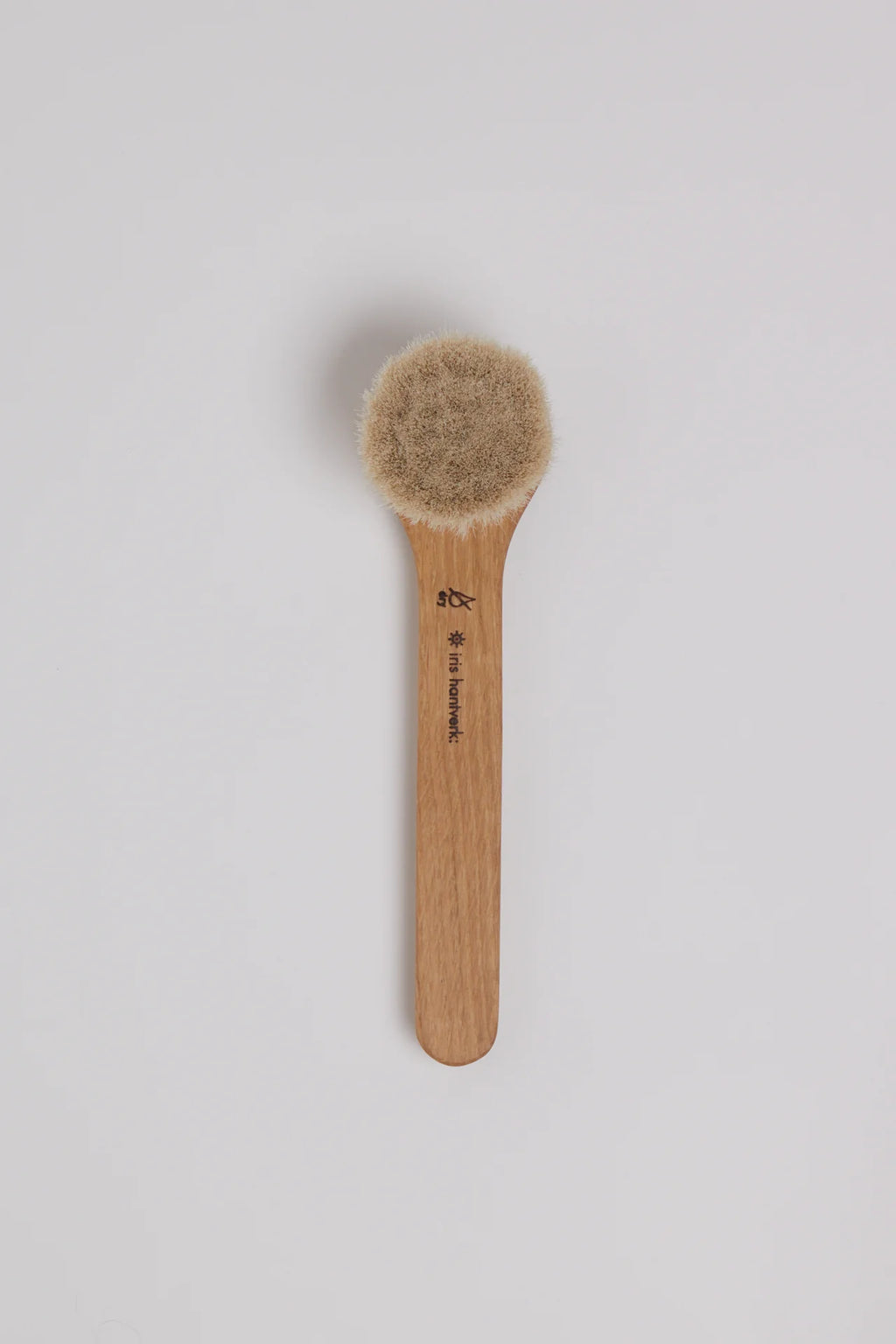 Wooden brush with bristle head on a light gray background