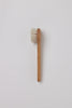 Wooden brush with white bristles on a light gray background