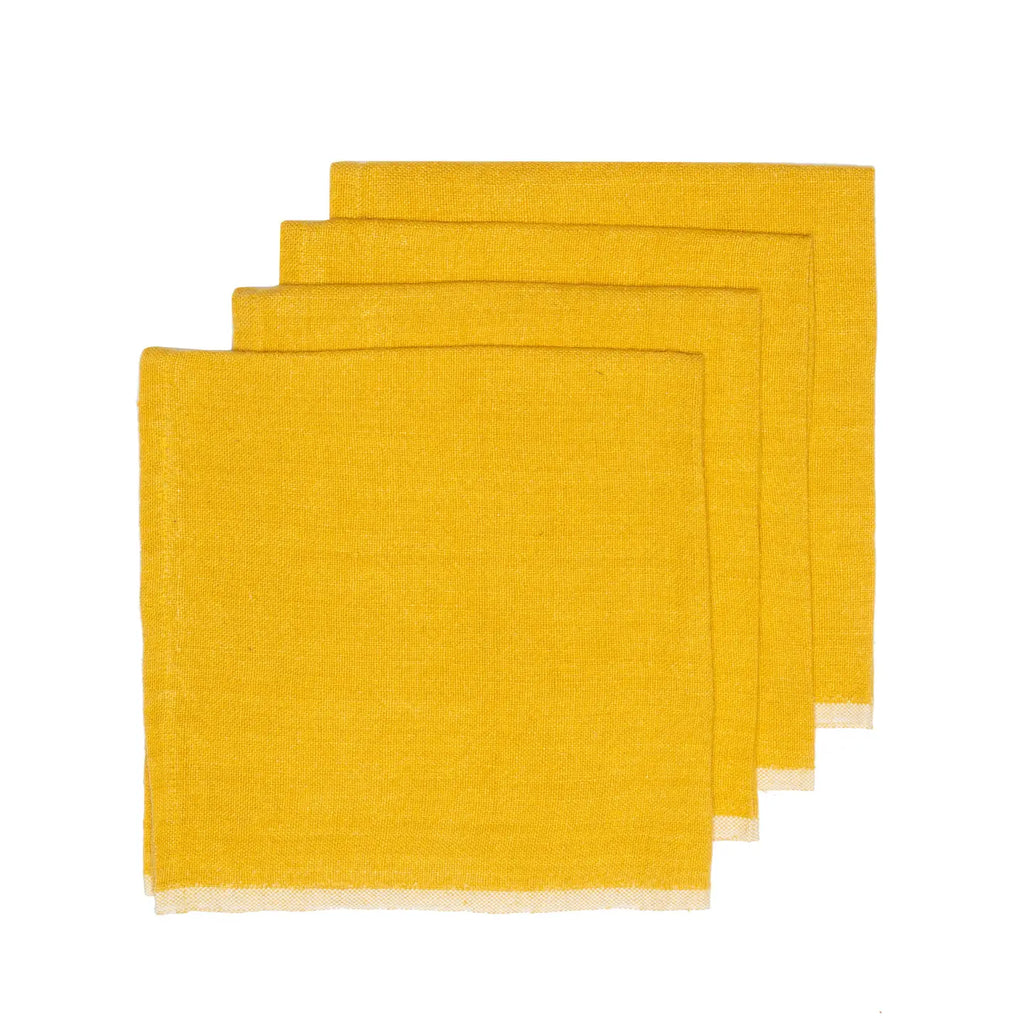 Set of four mustard yellow napkins on a white background