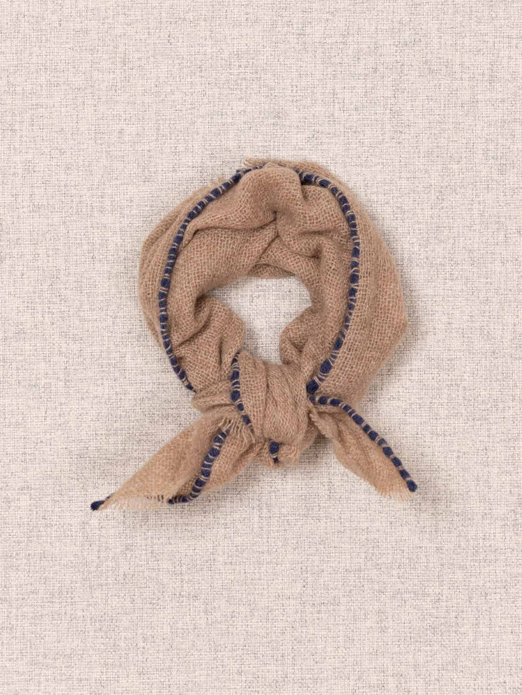 Beige scarf with blue accents on a beige textured background