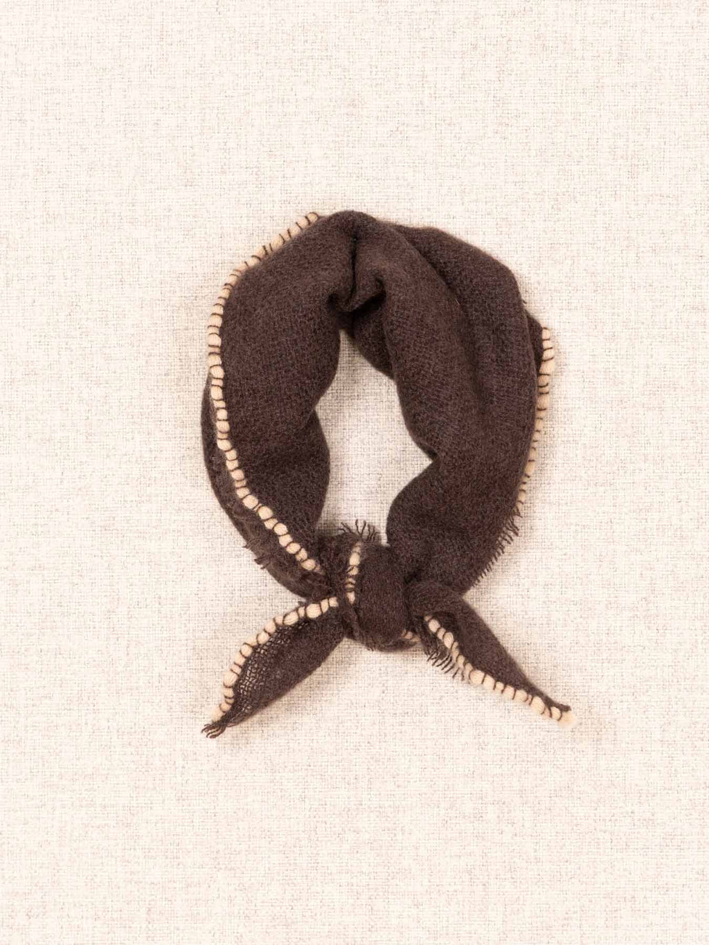 Brown scarf with fringe on a beige background
