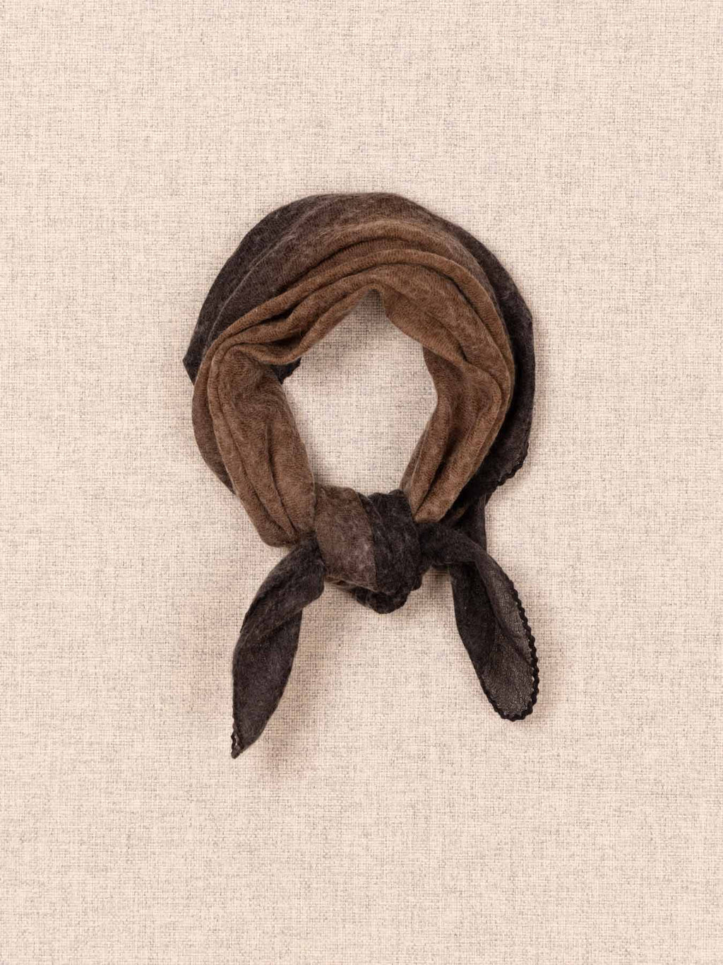 Brown scarf tied into a knot on a beige textured background