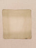 A square scard made of a soft cashmere, laid flat against a textured beige linen background.