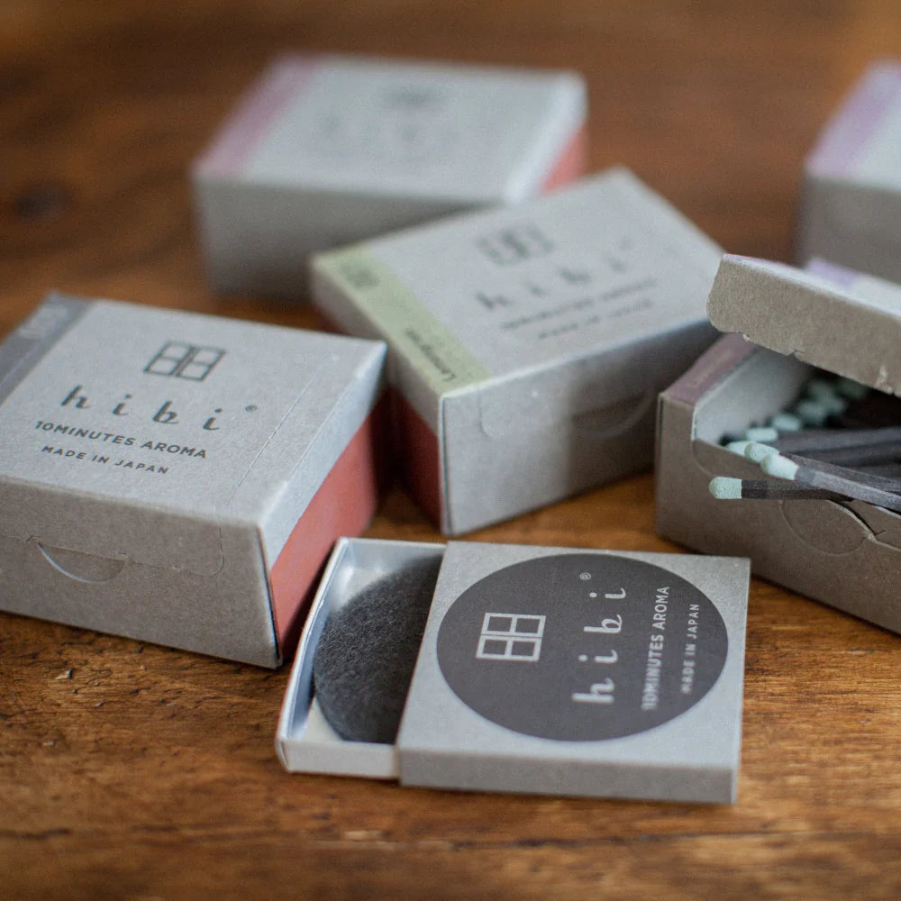 Hibi incense sticks in open packaging on a wooden surface
