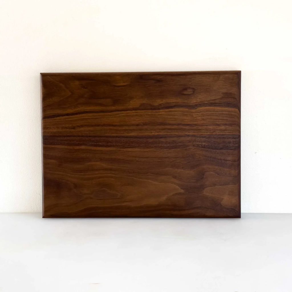 A rectangular dark brown wooden board with prominent natural wood grain patterns, displayed against a plain white background.