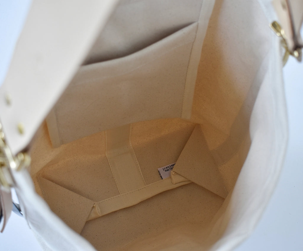 Close-up of a beige canvas tote on a light background