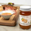 Jar of Kankitsu Labo Amanatsu & Lemon spread on a table with a bowl of soup and a plate of food in the background.