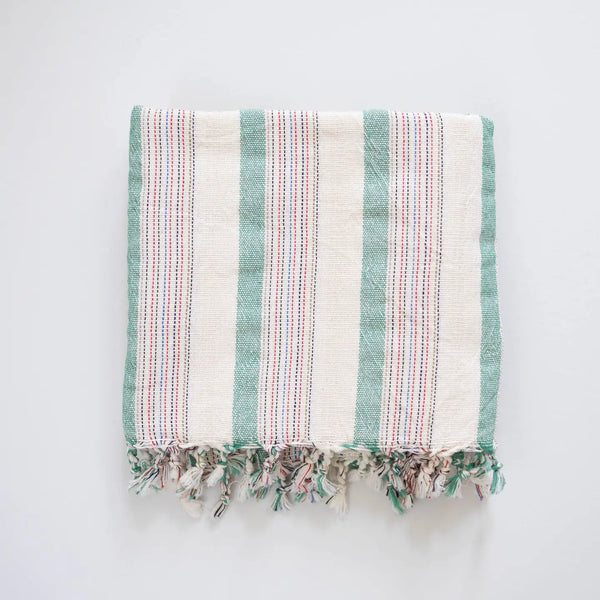 Striped towel with fringes on a light gray background