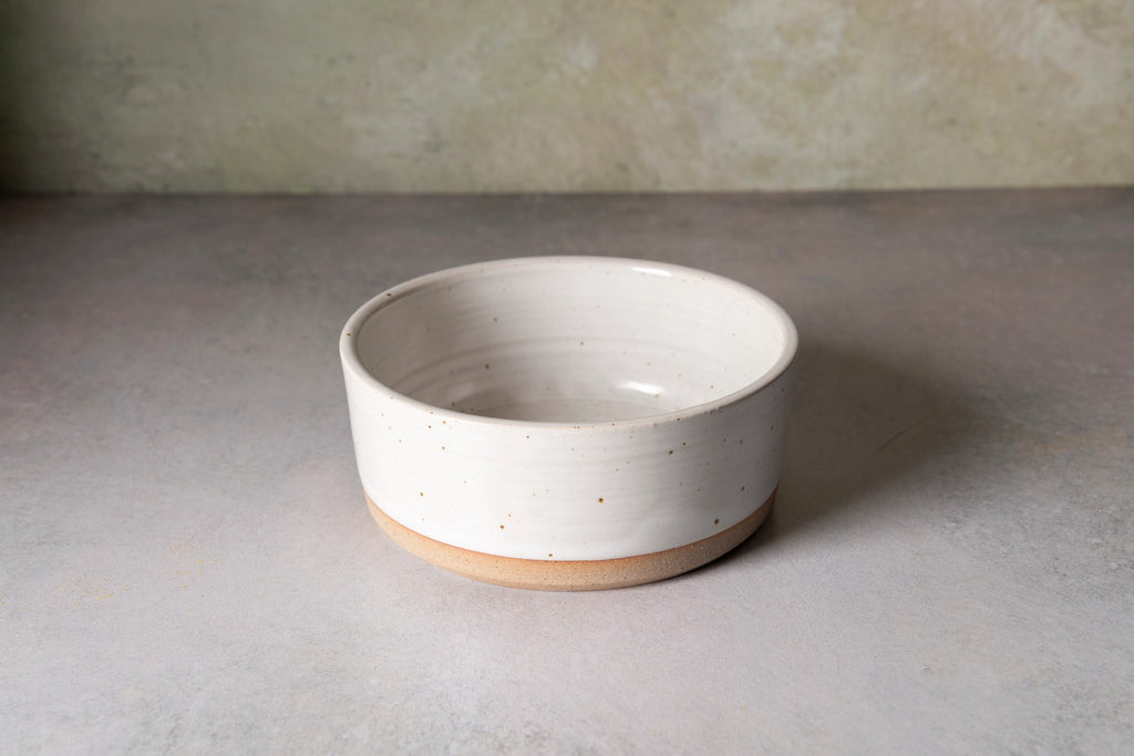 White ceramic bowl on a gray surface with a neutral background