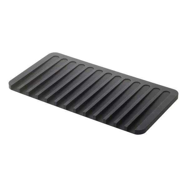 A dark gray rectangular mat with parallel raised ridges, shown at an angle on a plain white background.