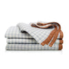 Stack of folded checkered napkins with a brown border on a white background