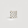 Small pouch with blue polka dots on a light gray background