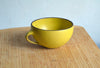 Yellow mug on a wooden surface with a light blue background