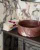 Marble-patterned sink and towels on a vanity with marble walls.