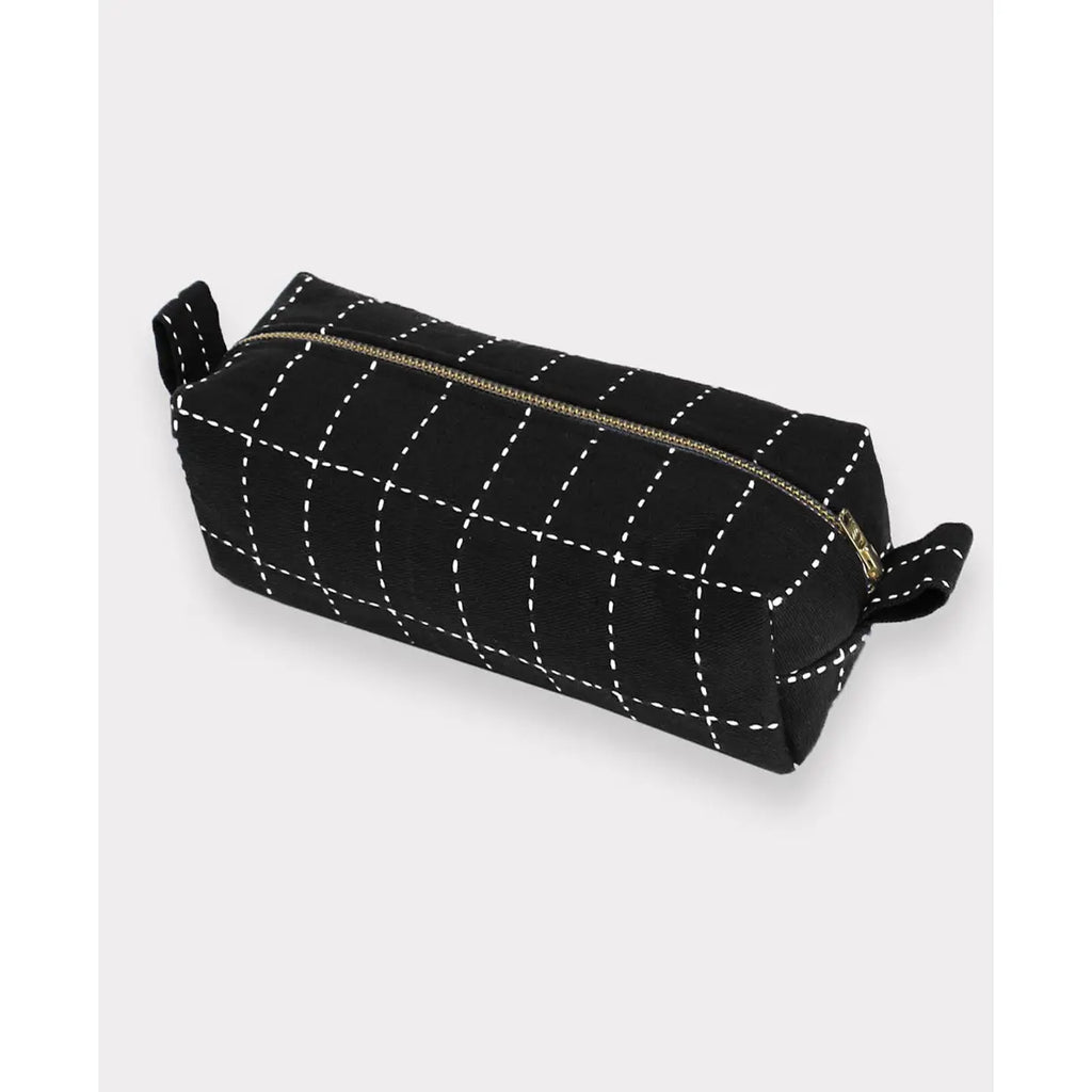 Black toiletry bag with white stitching on a light gray background
