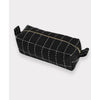 Black toiletry bag with white stitching on a light gray background