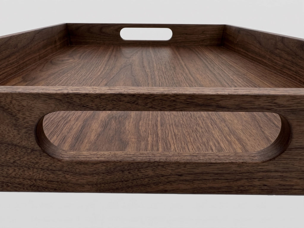 Close-up of a dark brown wooden serving tray with a natural wood grain finish and a cutout handle, shown against a light gray background.