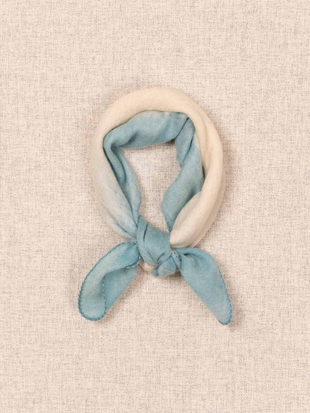 Blue and white cashmere scard on a textured beige background
