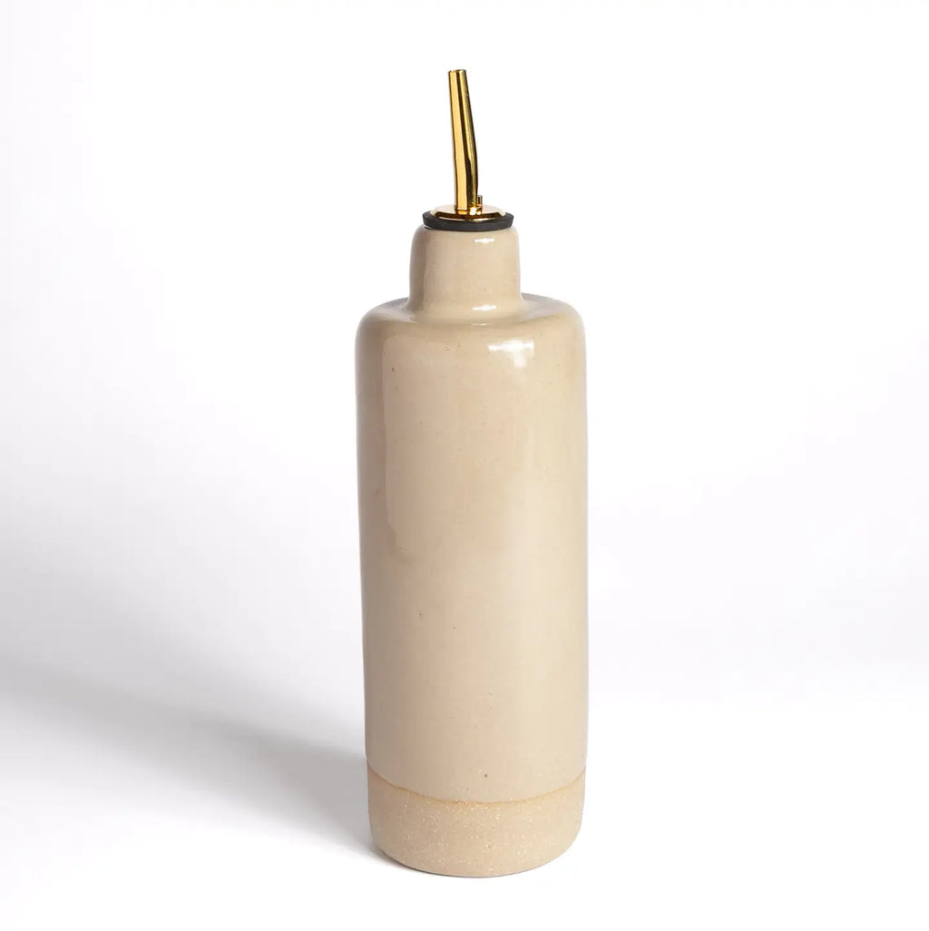 Beige ceramic bottle with gold cap on a white background