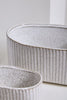 Two textured ceramic planters on a light background